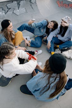 Group of teenage girls laughing and enjoying time together at a skatepark.
