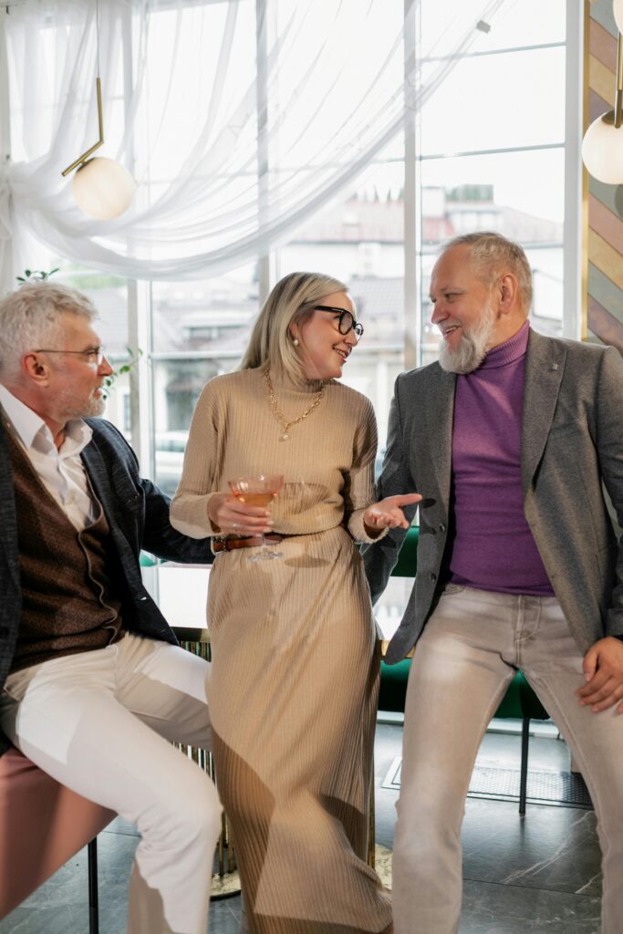 Senior adults laughing and talking in a cozy indoor setting, capturing joyful moments.